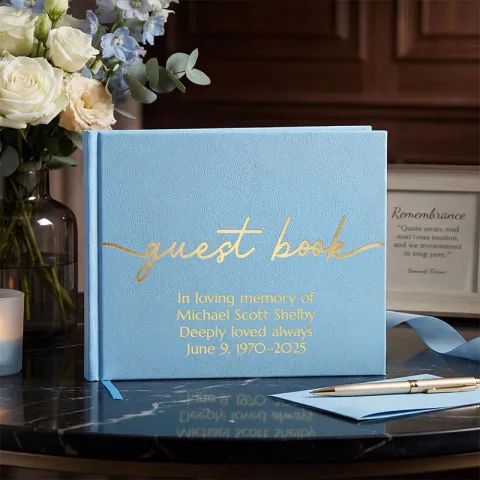 Light blue vegan leather guest book with a smooth textured cover featuring gold script text “guest book” and customizable lines “Custom Text Here Optional Custom Text Here Optional Custom Text Here Optional Custom Text Here.” This all occasion guestbook i