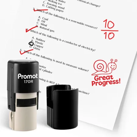 Black self inking stamp and removable cap displayed beside a graded science worksheet marked with red check marks, a “10/10” score, and a smiling snail stamp that says “Great Progress!” The worksheet includes multiple choice science questions, and this in